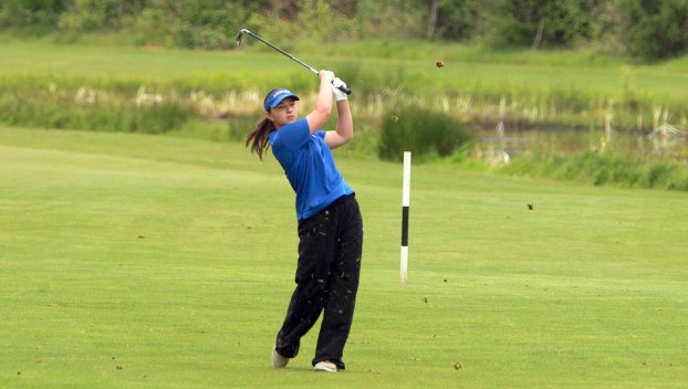 Barlow golfer Ella Wishart in a blue top and black bottoms swings a golf club on a sunny day out on the green during the Regional Golf Tournament